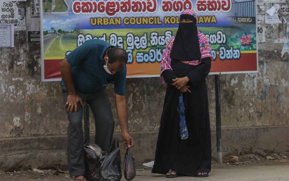  Sri Lankan Muslim woman (R) wearing a veil on a road side in Colombo, Sri Lanka, - Shutterstock/Shutterstock
