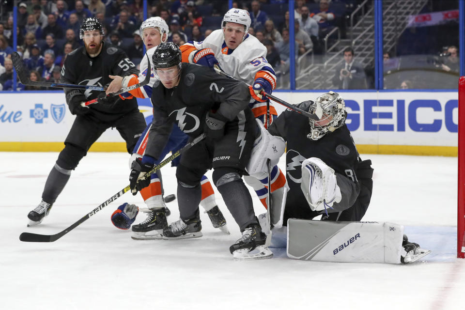 Tampa Bay Lightning goaltender Andrei Vasilevskiy, of Russia, makes a save as defensemen Luke Schenn (2) and Braydon Coburn (55) defend against New York Islanders' Casey Cizikas (53) and Leo Komarov (47) during the first period of an NHL hockey game Saturday, Feb. 8, 2020, in Tampa, Fla. (AP Photo/Mike Carlson)