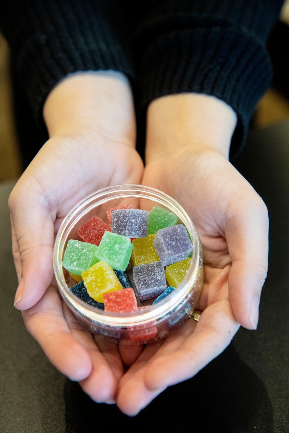 Salina Evans holds a container of CBD gummies at CBD Central in Hendersonville November 5, 2021.