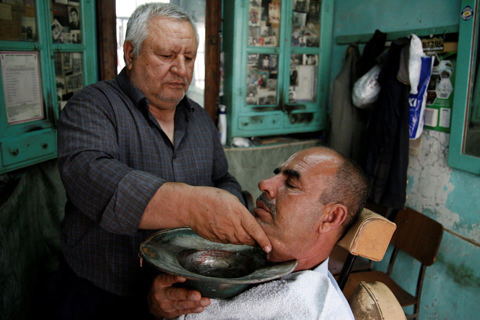 <p>Ali Marili, 62, uses a chopper basin after shaving a man’s beard at his barbershop in Kilis, Turkey. </p>