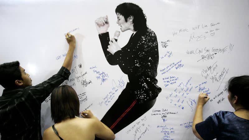 Fans write condolence notes beside a Michael Jackson portrait during a rally in memory of him in Kuala Lumpur, Malaysia, Sunday, June 28, 2009.