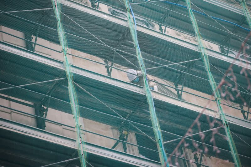 A worker is seen on a scaffolding of a building in Rome