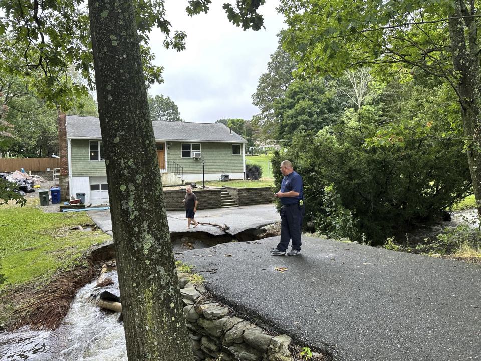 Home owner John Schuller assesses flood damage to the road leading to his house in Leominster, Mass., Tuesday, Sept. 12, 2023. (AP Photo/Michael Casey)