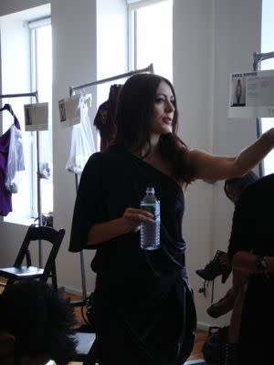 Catherine Malandrino instructs dressers on how to style a model backstage. She is so pretty!