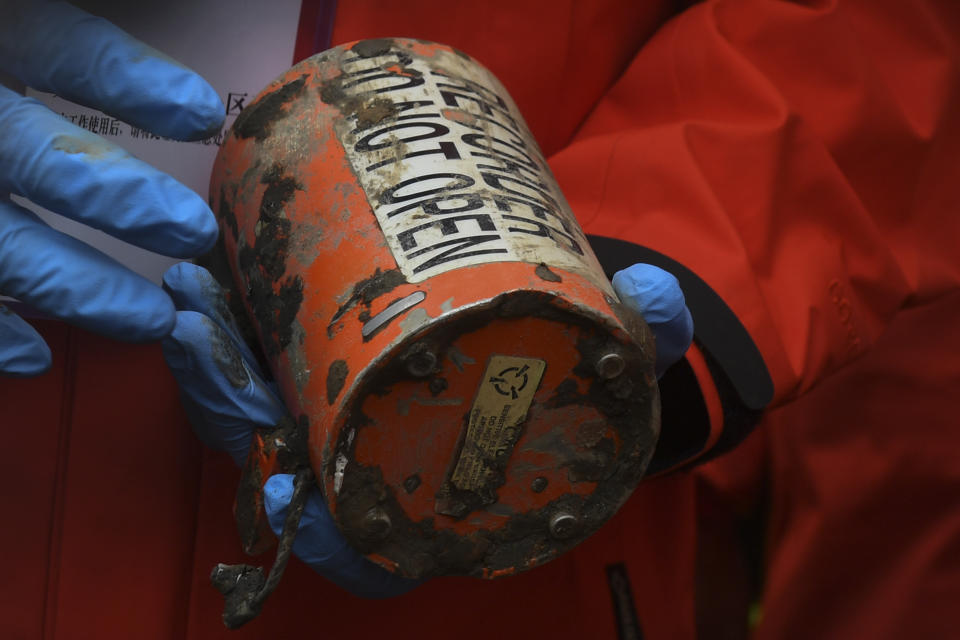 FILE - In this photo released by Xinhua News Agency, a search and rescue worker holds the second orange-colored "black box" recorder which recovered at the China Eastern flight crash site in Tengxian County in southern China's Guangxi Zhuang Autonomous Region on March 27, 2022. Experts still are investigating the cause of the crash of a China Eastern Airlines jetliner that plunged into a mountainside one year ago, killing more than hundred people aboard, the government said on Monday, March 20, 2023. (Lu Boan/Xinhua via AP, File)