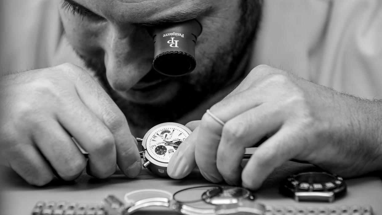  A professional inspecting a luxury watch. 