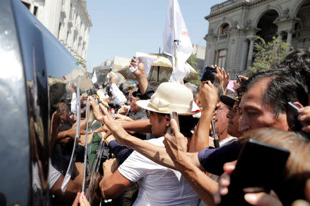 Supporters of Peru's former President Alan Garcia, who killed himself this week, touch the hearse carrying his remains, in Lima, Peru April 19, 2019. REUTERS/Guadalupe Pardo