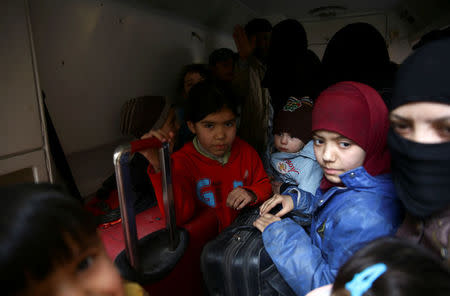 Children hold suitcases during evacuation from the besieged town of Douma, Eastern Ghouta, in Damascus, Syria, March 13. REUTERS/Bassam Khabieh