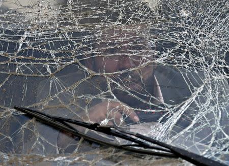 A man prepares to drive a damaged car away from the site of a suicide attack in Kabul March 25, 2015. REUTERS/Mohammad Ismail T