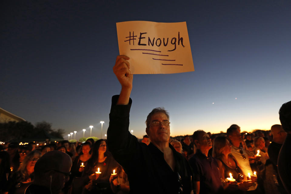 Tausende Menschen gedenken in Florida den Opfern des Amoklaufs. Ein Mann hält ein Schild mit der Aufschrift “Enough” in die Höhe. (Bild: Getty Images)