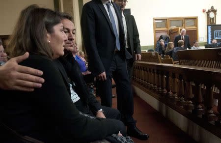 Parents of Diren Dede, mother Gulcin (L) and father Celal Dede embrace before the opening of court inside the Missoula County Courthouse in Missoula, Montana December 4, 2014. REUTERS/Arthur Mouratidis