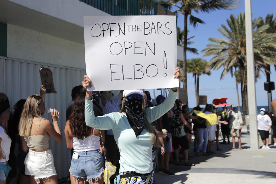 A woman participates in a "Right to Work" rally outside of the Elbo Room bar , which remains closed, during the new coronavirus pandemic, Tuesday, June 16, 2020, in Fort Lauderdale, Fla. Across Florida, bars were part of the Phase 2 reopenings that occurred earlier in June, except in three counties in South Florida. (Lynne Sladky/AP)