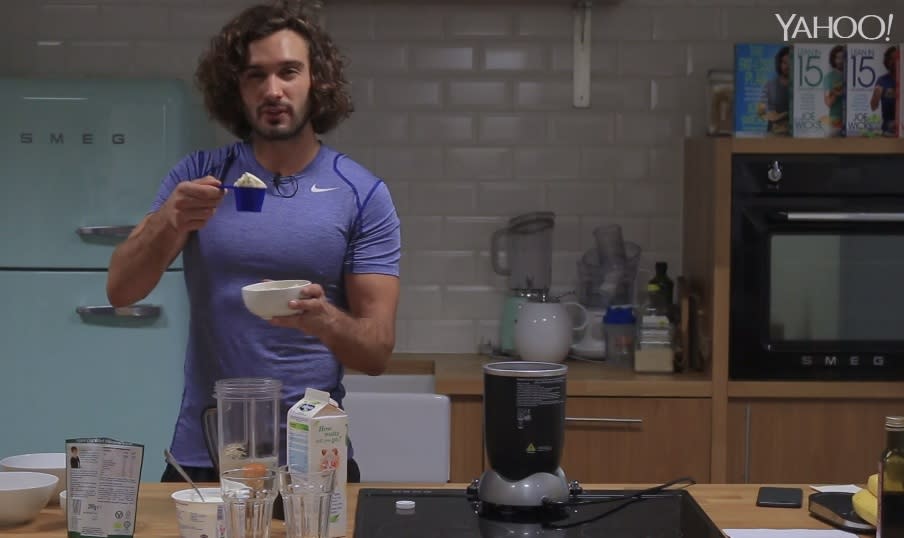 Joe Wicks whisks up a post-workout shake in his kitchen,