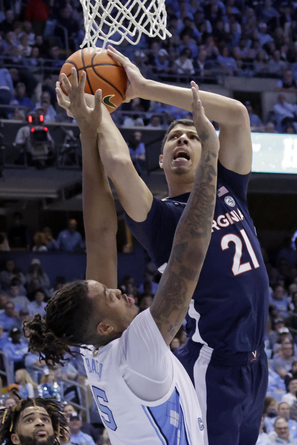 Virginia forward Kadin Shedrick (21) drives against North Carolina forward Armando Bacot (5) during the second half of an NCAA college basketball game Saturday, Feb. 25, 2023, in Chapel Hill, N.C. (AP Photo/Chris Seward)