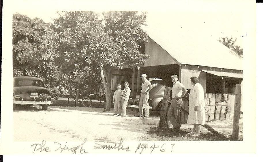 Smith's citrus packing house, Estero (Lee County) Florida in 1946. (l to r: Ray Smith, Kay Smith, Hugh Smith, George Smith, Della Smith) White guava tree in front of the packing house. Large electrical fruit washer and sorter inside.