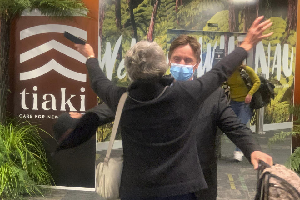 A passenger arriving from Sydney at the Wellington International Airport hugs loved one in Wellington, New Zealand Monday, April 19, 2021. The start of quarantine-free travel was a relief for families who have been separated by the coronavirus pandemic as well as to struggling tourist operators. (AP Photo/Nick Perry)