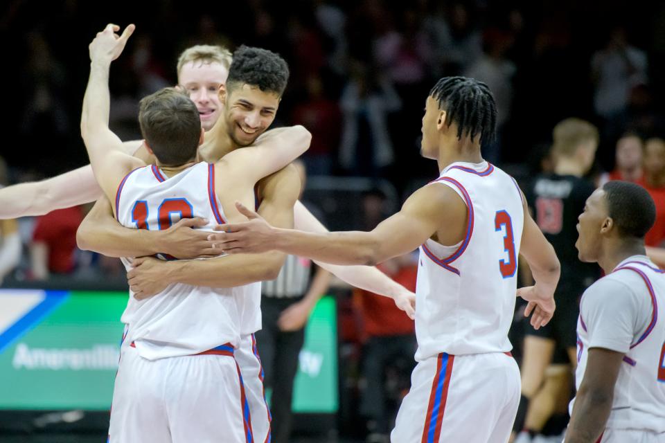 Bradley's Malevy Leons, facing,hugs Connor Hickman (10) as teammates Rienk Mast, background, Duke Deen, far right, and Zek Montgomery join in to celebrate the Braves' 79-75 overtime win against Illinois State on Wednesday, Jan. 25, 2023 at Carver Arena.