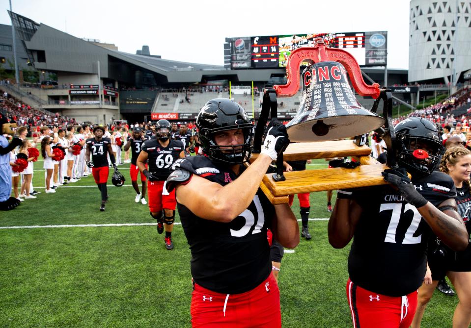 Cincinnati Bearcats offensive lineman Lorenz Metz (51) and Cincinnati Bearcats offensive lineman James Tunstall (72) carry the Victory Bell after the NCAA football game on Saturday, Sept. 4, 2021, at Nippert Stadium in Cincinnati. Cincinnati Bearcats defeated Miami Redhawks 49-14. 