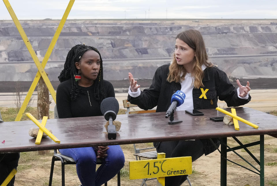 FILE - Activists Luisa Neubauer, from Germany, right, and Elizabeth Wathuti, from Kenya, talk to the media at a news conference at the Garzweiler open-cast coal mine near Luetzerath, western Germany, Sunday Oct. 16, 2022. About 1,000 miles away from Ukraine, Luetzerath is an indirect victim of the war as the town will soon make way for the expansion of a nearby coal mine. Wathuti said she couldn’t understand how Germany could justify burning more coal when the impacts of climate change are already becoming apparent. (AP Photo/Martin Meissner, File)