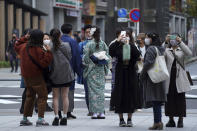 People wearing protective masks to help curb the spread of the coronavirus visit Asakusa district Tuesday, Nov. 24, 2020, in Tokyo. The Japanese capital confirmed more than 180 new coronavirus cases on Tuesday. (AP Photo/Eugene Hoshiko)