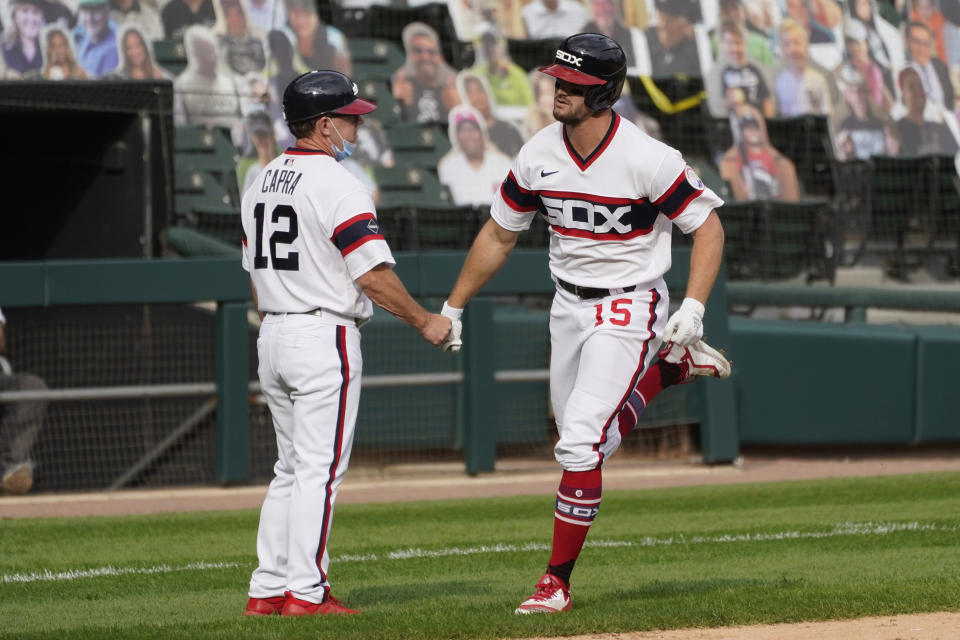 Chicago White Sox's Adam Engel, right, is congratulated by third base coach Nick Capra after his solo home run during the fifth inning of a baseball game against the Chicago Cubs in Chicago, Sunday, Sept. 27, 2020. (AP Photo/Nam Y. Huh)