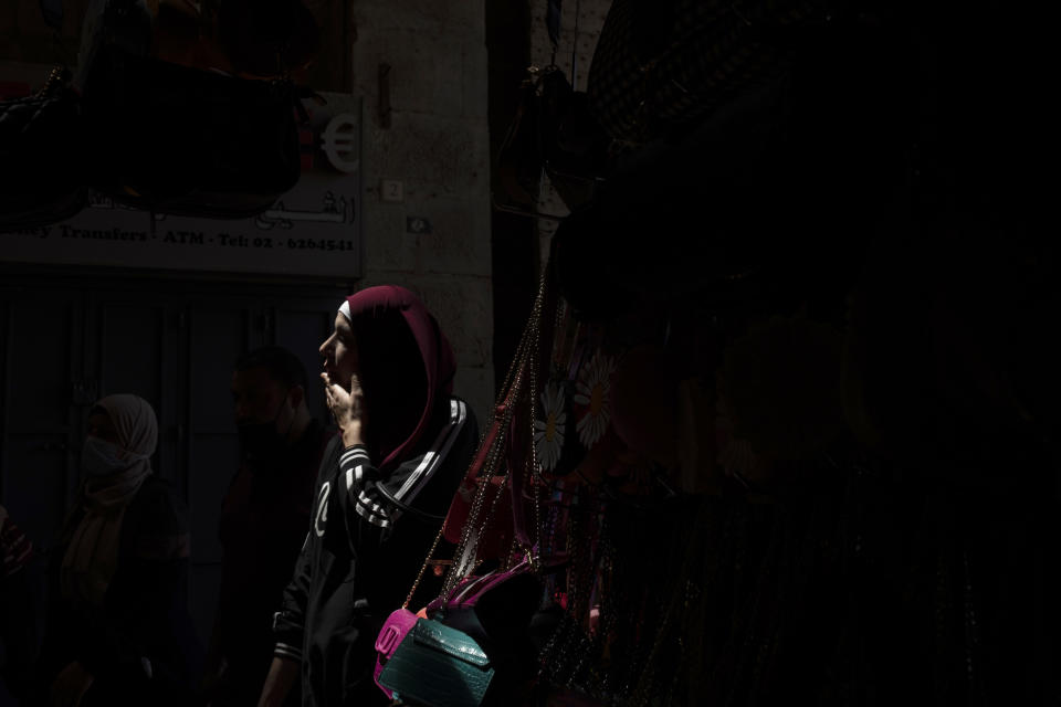 A Palestinian woman passes through Damascus Gate to leave the Old City of Jerusalem after Friday prayers during the Muslim holy month of Ramadan, on Friday, April 23, 2021. Israeli police say 44 people were arrested and 20 officers were wounded in a night of chaos in Jerusalem, where security forces separately clashed with Palestinians angry about Ramadan restrictions and Jewish extremists who held an anti-Arab march nearby. (AP Photo/Maya Alleruzzo)