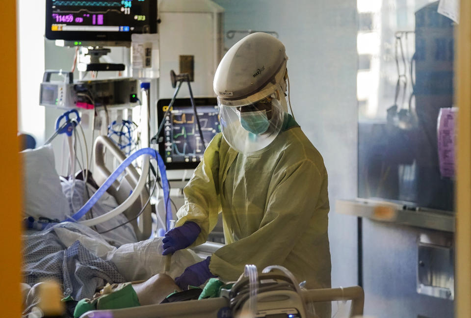 FILE - In this Wednesday, Jan. 13, 2021, file photo, a health care worker tends to a COVID-19 patient in the intensive care unit at Santa Clara Valley Medical Center during the coronavirus pandemic in San Jose, Calif. The coronavirus death toll in California surpassed 50,000 on Wednesday, Feb. 24, 2021, marking about one-tenth of the U.S. total from the pandemic. (AP Photo/Jeff Chiu, File)