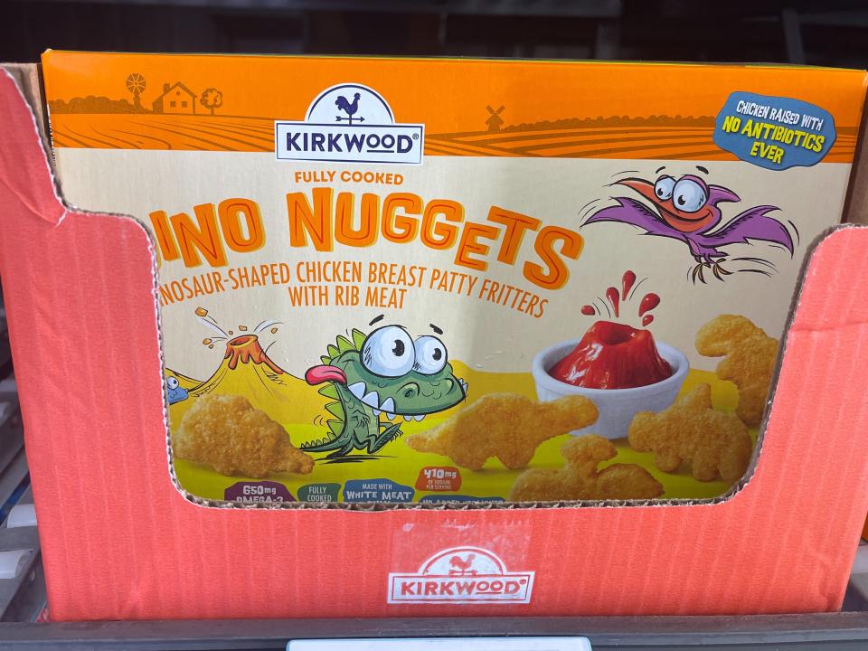 Box with "Dino Nuggets" text and illustration of a dinosaur inside of a cardboard box on a shelf