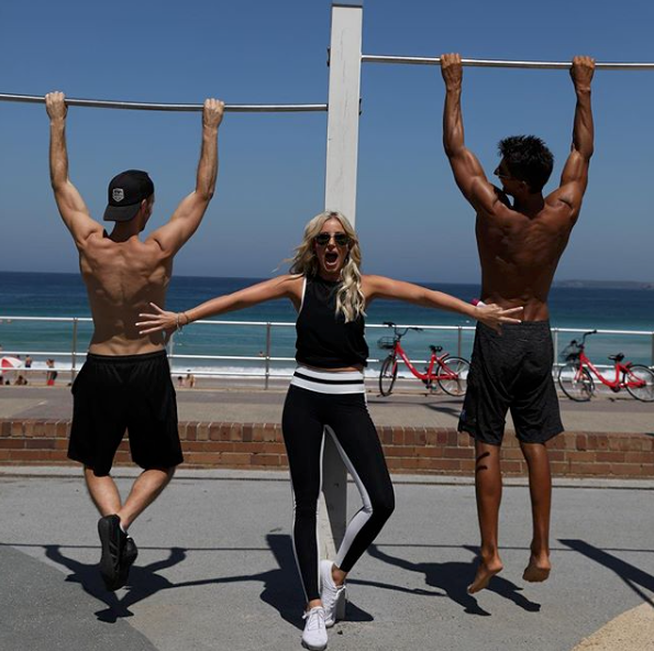 <p>She poses in workout gear between some shirtless hunks. We are a little envious. Source: Instagram/roxyjacenko </p>