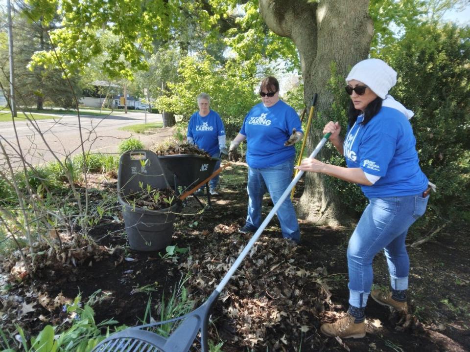 Cooper Standard customer service representatives, from left, Heidi Stull, Carrie Jackson and Staci Angelo work in a flower bed at the Reeves Museum in Dover during Friday's United Way of Tuscarawas County Day of Caring.