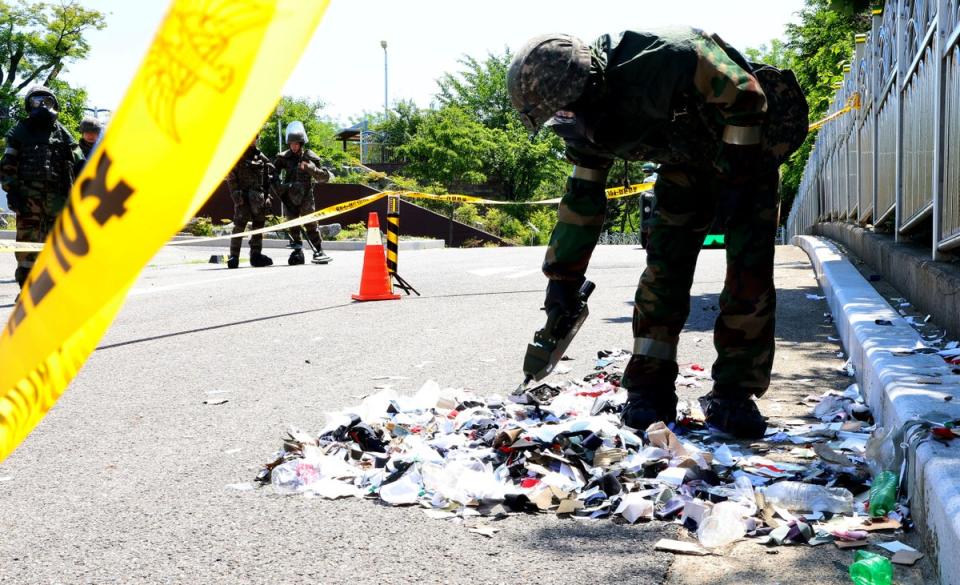 South Korean soldier wearing protective gears checks the trash from a balloon presumably sent by North Korea, in Incheon, South Korea (AP)