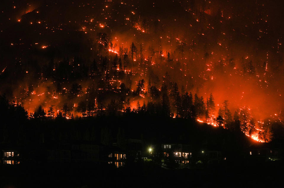 The McDougall Creek wildfire burns on the mountainside above houses in West Kelowna, B.C., on Friday, August 18, 2023. THE CANADIAN PRESS/Darryl Dyck