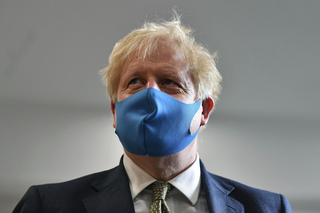 File - In this Monday, July 13, 2020 file photo, Britain's Prime Minister Boris Johnson, wearing a face mask, visits the headquarters of the London Ambulance Service NHS Trust in London, Monday July 13, 2020. The British government insists that science is guiding its decisions as the country navigates its way through the coronavirus pandemic. But a self-appointed  group of independent experts led by a former government chief adviser says it sees little evidence-based about Britain’s response. Unlike other countries, the scientific opposition to Britain’s approach is remarkably organized. The independent group sits almost in parallel to the government’s own scientists, assesses the same outbreak indicators and has put out detailed reports on issues such contact tracing, reopening schools and pubs, and relaxing social distancing. (Ben Stansall/Pool via AP, File)