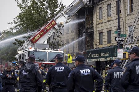 New York Police Department (NYPD) officers and firefighters respond to an explosion and house fire the Brooklyn borough of New York, October 3, 2015. REUTERS/Rashid Umar Abbasi