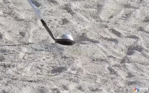 Television footage showed Reed brushing back sand from directly behind the ball 