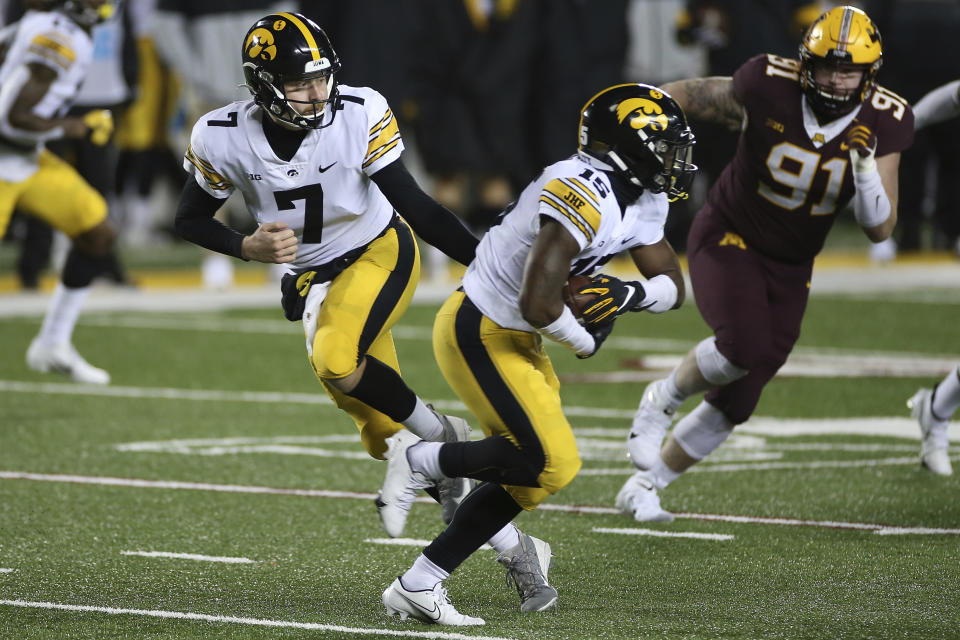 Iowa quarterback Spencer Petras (7) hands the ball off to running back Tyler Goodson (15) during the second half of the team's NCAA college football game against Minnesota, Friday, Nov. 13, 2020, in Minneapolis. Iowa won 35-7. (AP Photo/Stacy Bengs)