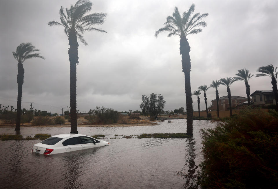 A car is partially submerged in floodwaters.