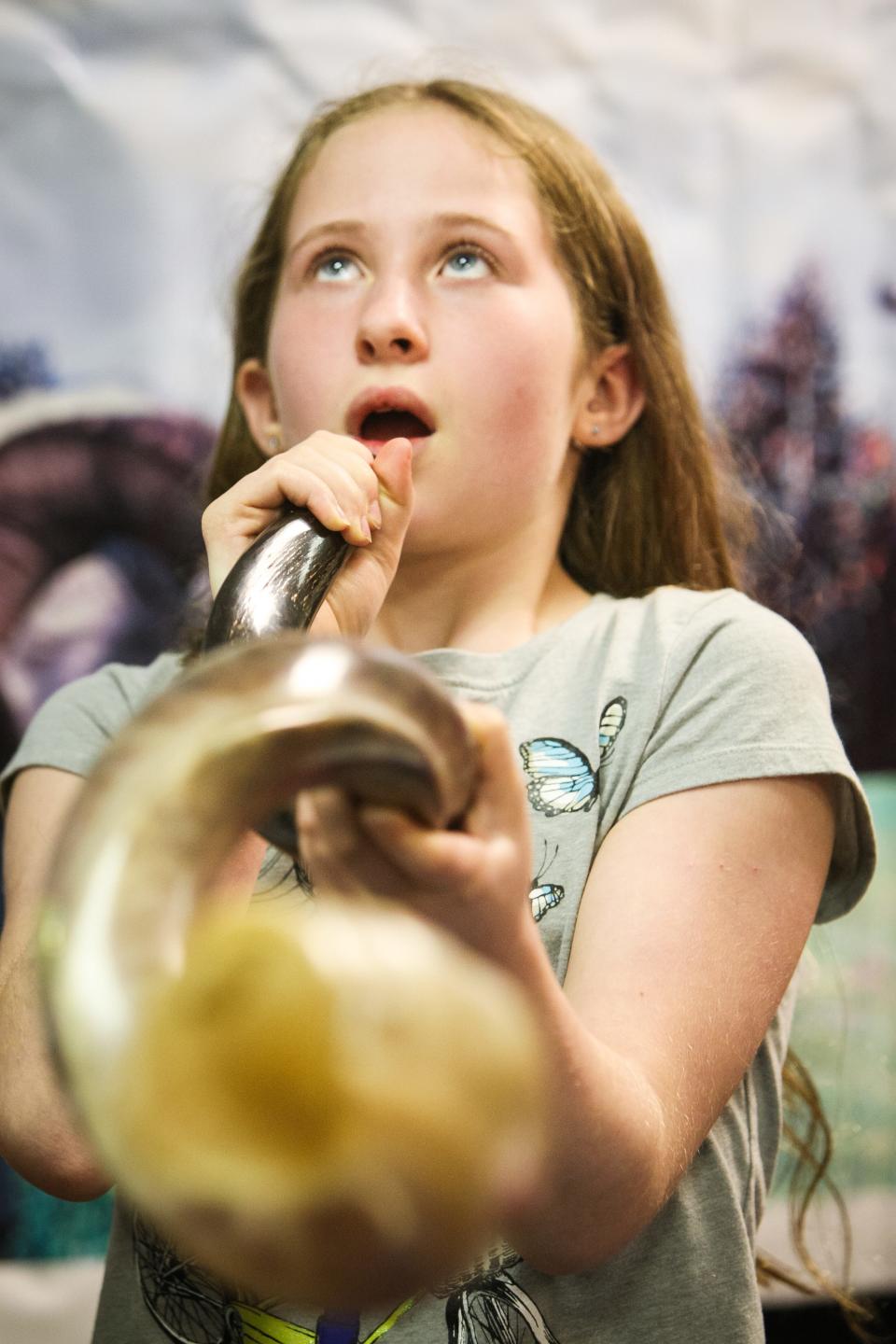 Shira Beals, 10, takes a deep breath as she blows into a Shofar. Children at the Albert Einstein Academy learn about the ancient art of creating a shofar Thursday, September 18, 2014. The “Shofar” is a semi-musical horn used by Jews on their New Year, Rosh Hashanah, and on Yom Kippur.