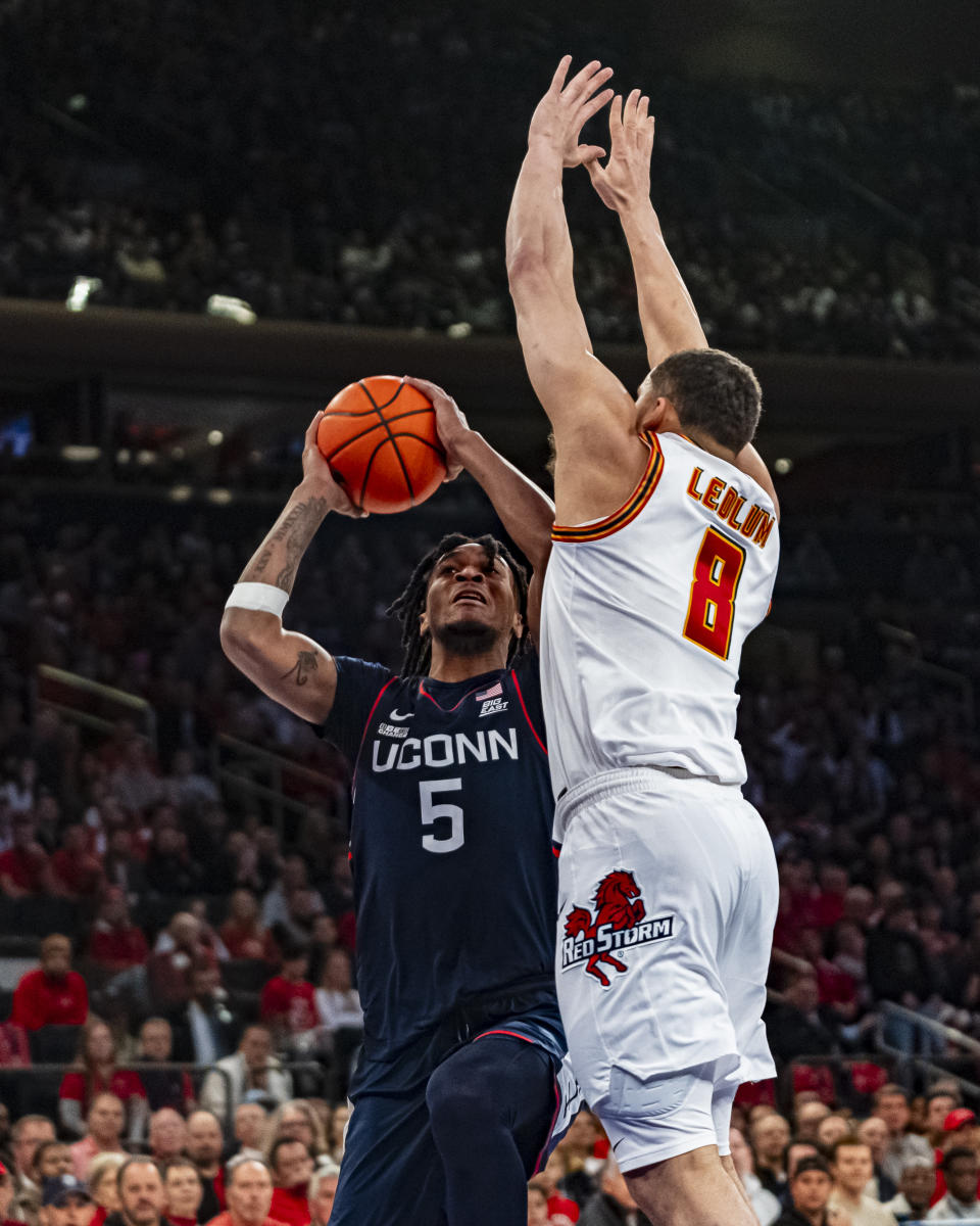 UConn guard Stephon Castle (5) attempts a shot over St. John's guard Chris Ledlum (8) during the first half of an NCAA college basketball game on Saturday, Feb. 3, 2024, in New York. (AP Photo/Peter K. Afriyie)