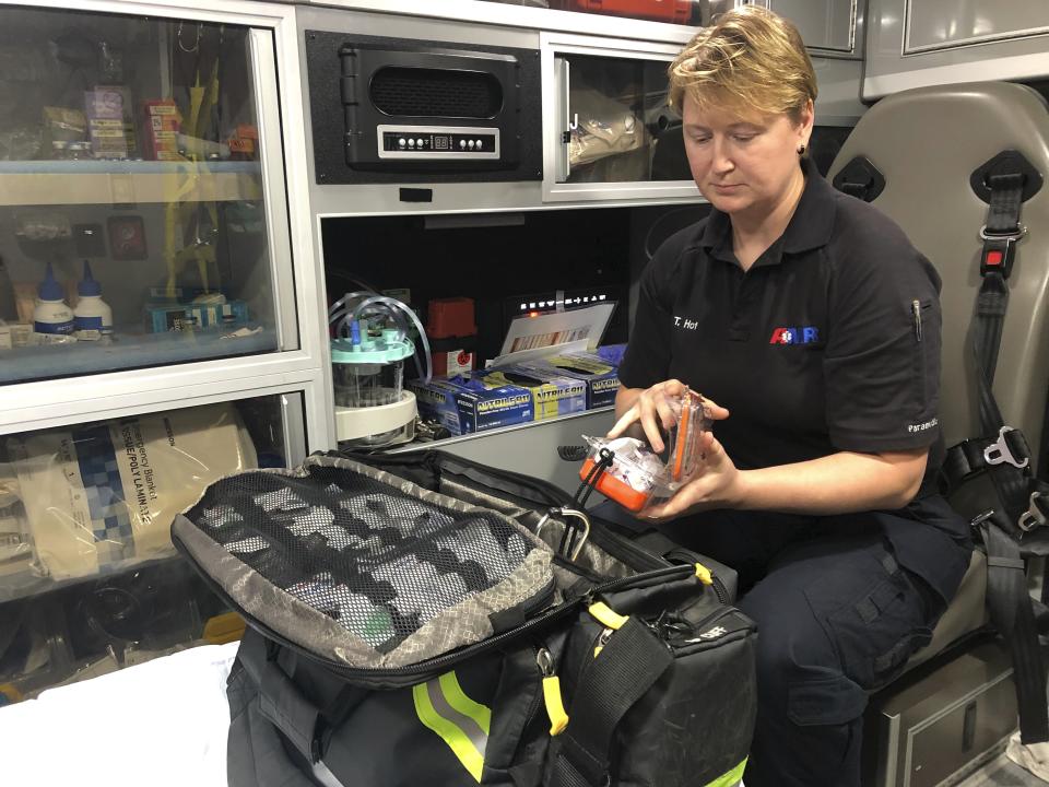 In this photo taken Sept. 10, 2019, Tifphany Hofstetter, a lead paramedic with American Medical Response, organizes her emergency medical supplies inside an ambulance in Portland, Ore. Hofstetter had to jump out the side door of her ambulance earlier this year when a patient jumped off his gurney and crawled through the breezeway to take over the ambulance steering wheel from her partner. (AP Photo/Gillian Flaccus)