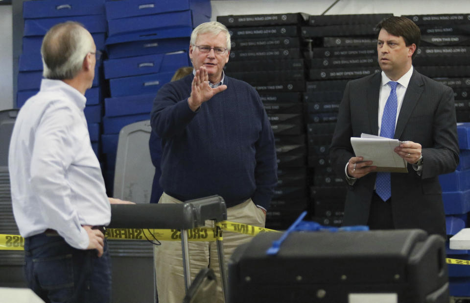 Kentucky 13th District House race candidate DJ Johnson, center, talks to election officials as Daviess County Attorney Claud Porter, left, looks on, and C. Michael Shull, III, a lawyer for Johnson, listens at right, during a recount of the Nov. 13, 2018 District House race at the Daviess County Operations Center in Owensboro, Ky., on Saturday, Feb 2, 2019. (Greg Eans/The Messenger-Inquirer via AP)