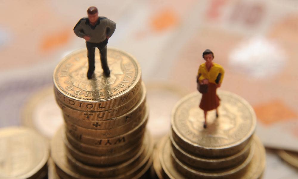 Plastic models of man and woman standing on pile of coins