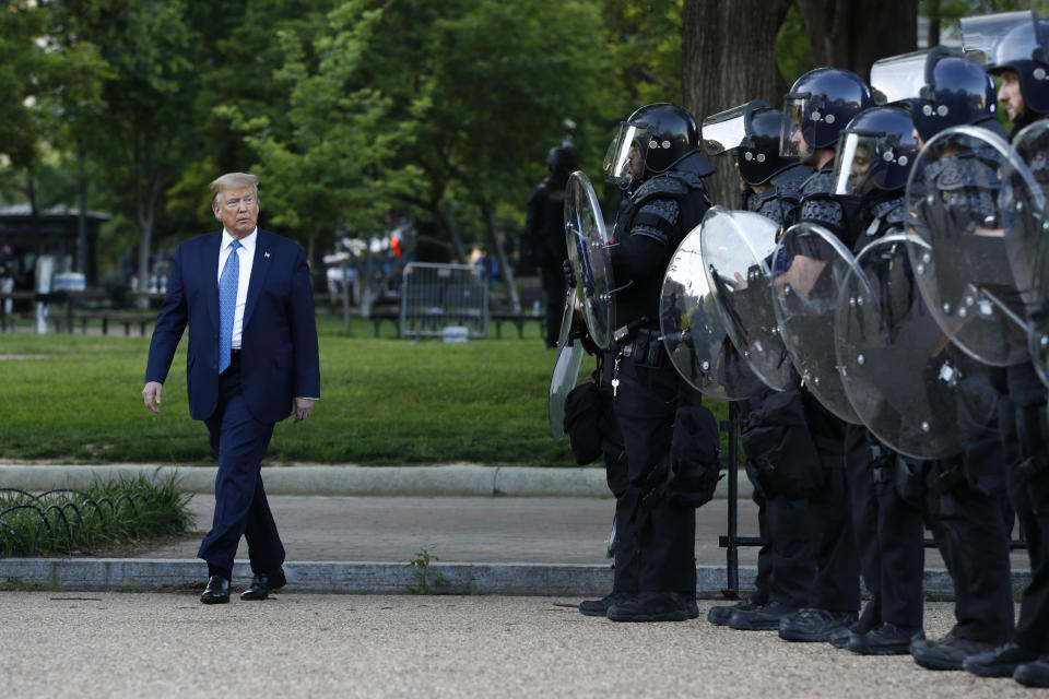 President Donald Trump walks past police in Lafayette Park after visiting outside St. John's Church across from the White House Monday, June 1, 2020, in Washington. Part of the church was set on fire during protests on Sunday night. (AP Photo/Patrick Semansky)