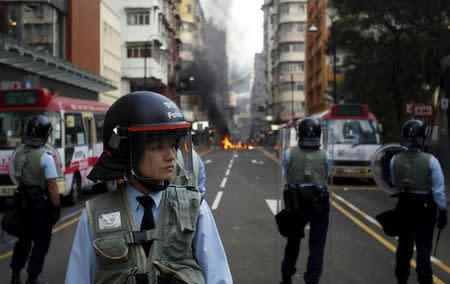 Riot police guard a street where a fire was set by protesters at Mongkok district in Hong Kong, China February 9, 2016. REUTERS/Liau Chung-ren