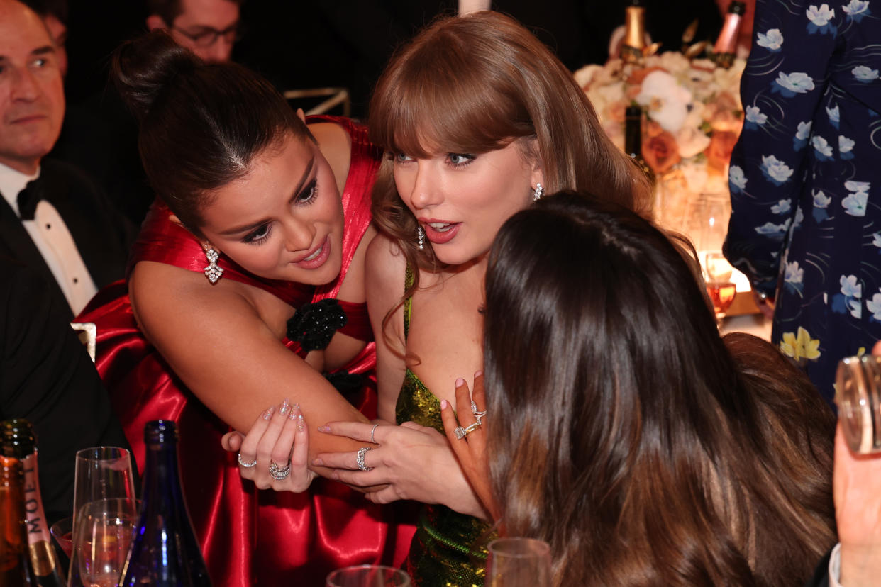 Selena Gomez and Taylor Swift embrace one another while chatting at the 2024 Golden Globe Awards.
