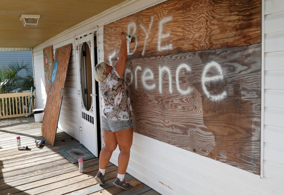 Lisa Evers of Oak Island, North Carolina, decorates her storm shutters before evacuating her house ahead of the arrival of Hurricane Florence. (Photo: Randall Hill / Reuters)