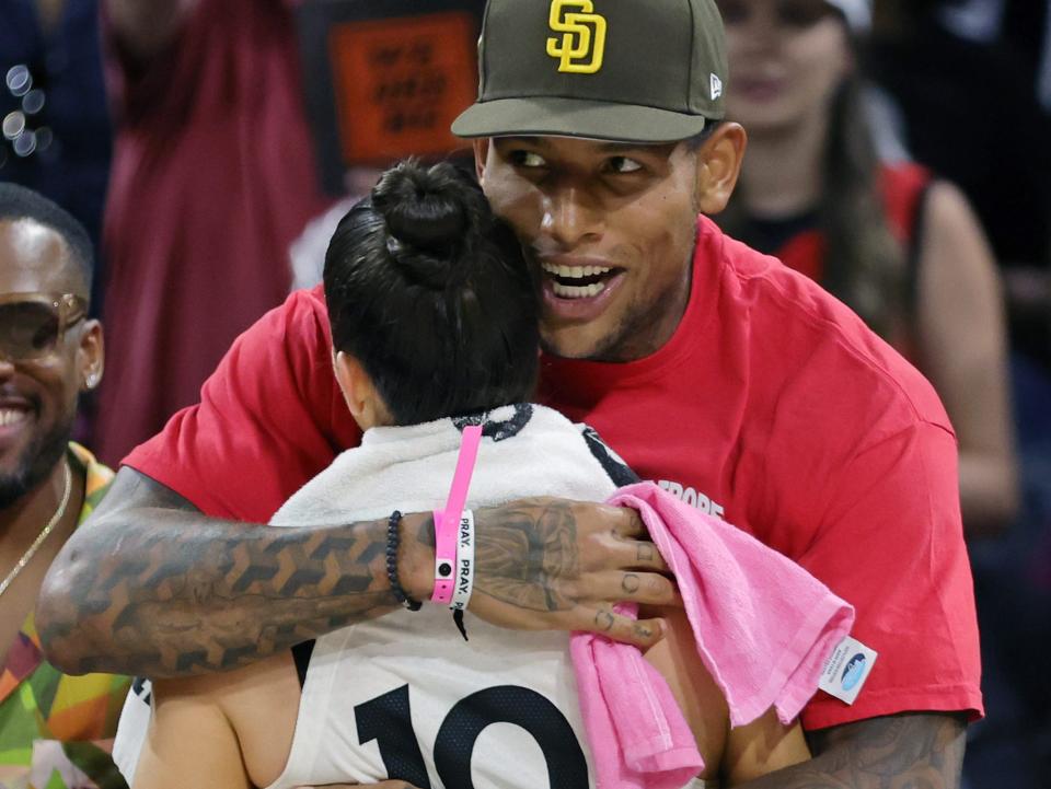 Darren Waller hugs Kelsey Plum after a Las Vegas Aces game.