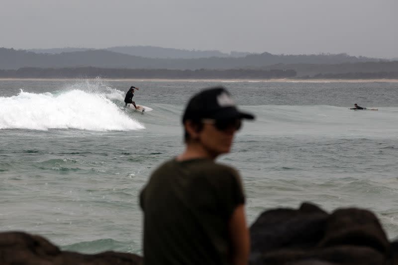 People surf in Bengello beach in Broulee