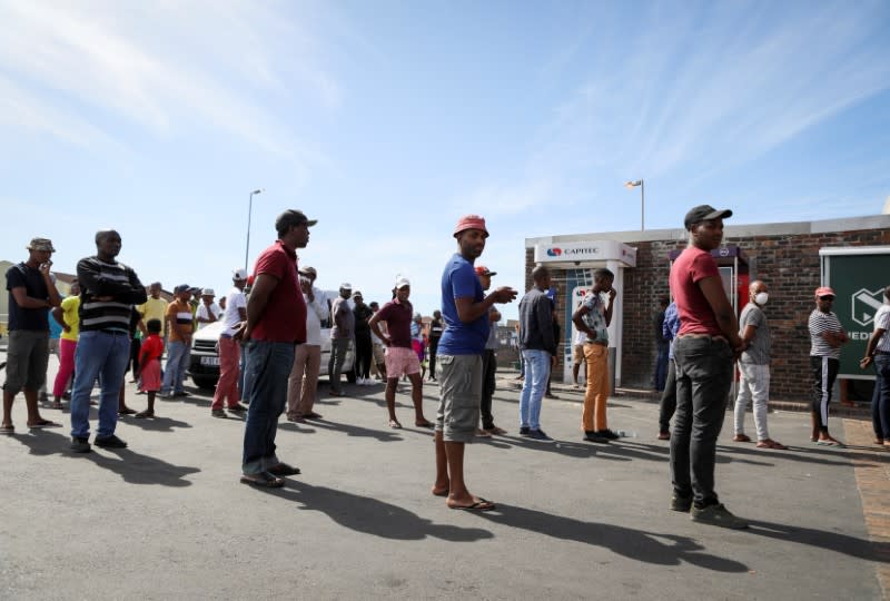 People queueing to withdraw cash from an ATM exercise social distancing, in Cape Town