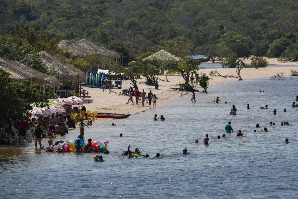 People swim in Alter do Chao, district of Santarem, Para state, Brazil, Thursday, Aug. 27, 2020. One of Brazil’s trendiest destinations, Alter do Chão welcomes up to 100,000 visitors each year in the high season, though considerably less in 2020 because of the COVID-19 pandemic. (AP Photo/Andre Penner)
